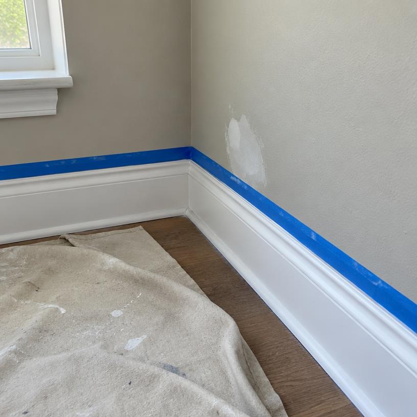 Close-up job photo of taped baseboard trim